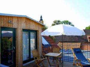 a patio with a table and chairs and an umbrella at Ferien am Roten Haus in Buckow
