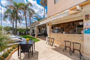 a patio with a table and chairs and a bar at B&B Annita in Porto Cesareo