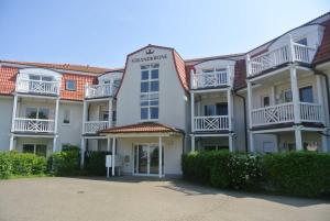 a large white apartment building with red roof at Residenz Strandkrone 09 in Kühlungsborn