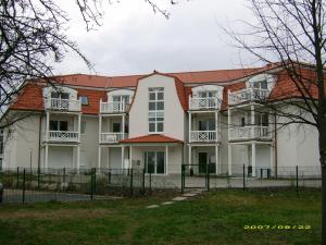 a large white house with a red roof at Residenz Strandkrone 09 in Kühlungsborn