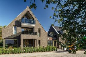 a brick house with a gambrel roof at Ferienwohnung Pinschieter in Born