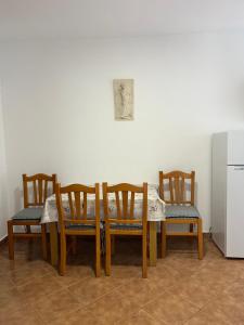 a dining room table with four chairs and a refrigerator at Apartment Sole in Poreč