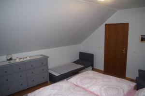 a bedroom with two twin beds and a dresser at Ferienwohnung Friedrichswalde in Bahretal +14 photos