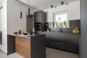 a kitchen with black cabinets and a counter top at Villa Fortuna - Private Pool and Garden Retreat in Labin