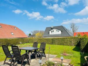 a patio with chairs and a table and a house at Ferienhaus SeeKrosch in Göhren-Lebbin