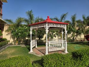 a gazebo with a red roof in a yard at Pink Mahal Hotel & Resort in Jaipur