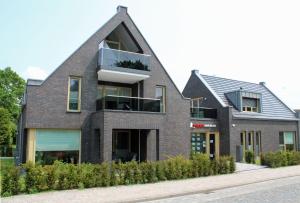 a brick house with a gambrel roof at Ferienwohnung Boddenschnacker in Born