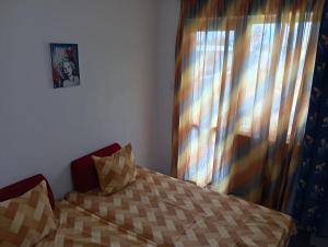 a bedroom with a bed and a window with curtains at Villa Savovi in Varna City