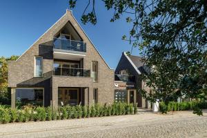 a brick house with a gambrel roof at Ferienwohnung To Huus in Born +32 photos