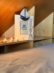 a picture of a boat on a shelf with candles at Tiny House cosy 4 personnes in Vaux-sur-Mer