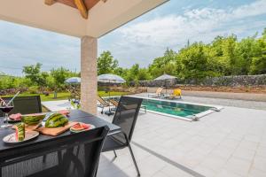 an outdoor patio with a table with food on it at Villa Fortuna - Private Pool and Garden Retreat in Labin