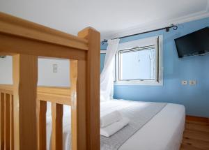 a blue bedroom with a bed and a window at Garifalakis House in Pollonia
