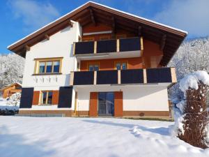 a house with solar panels on it in the snow at Ferienwohnung Helene in Sibratsgfäll