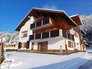 a house in the winter with snow on the ground at Ferienwohnung Helene in Sibratsgfäll