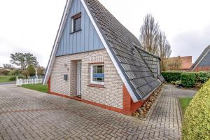 a small house with a gambrel roof at Ferienhaus Mina in Neuharlingersiel