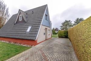 a house with a gray roof and a brick driveway at Ferienhaus Mina in Neuharlingersiel