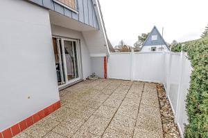 a white fence next to a white house at Ferienhaus Mina in Neuharlingersiel +37 photos
