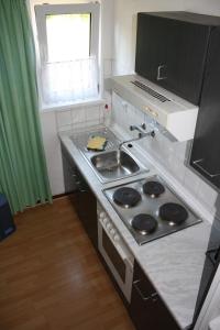 a kitchen with a stove and a sink and a window at Ferienhaus Stechlinsee 1 in Stechlin
