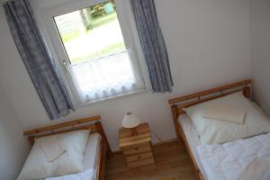 two twin beds in a room with a window at Ferienhaus Stechlinsee 1 in Stechlin