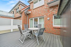 a patio with a table and chairs on a deck at Ferienwohnung Hamtor in Bensersiel