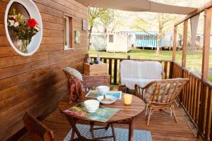 a patio with a table and chairs on a deck at Tiny House cosy 4 personnes in Vaux-sur-Mer