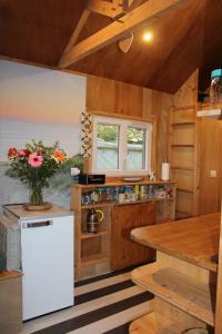 a kitchen with a white refrigerator and a table at Tiny House cosy 4 personnes in Vaux-sur-Mer +9 photos