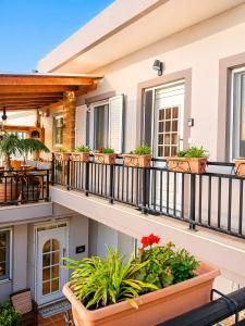a balcony with potted plants on a house at Diavaide Apartment in Dhiavaïdhé +3 photos