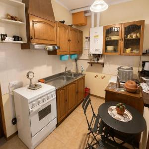 a kitchen with a table and a stove and a sink at Nido vista Lago Maggiore e isole borromee in Cissano