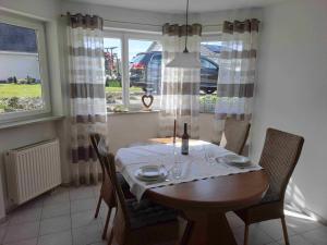 a dining room with a table and chairs and a window at Ferienwohnung Groß in Bermatingen