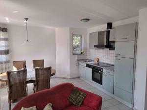 a kitchen with a red couch and a table at Ferienwohnung Groß in Bermatingen
