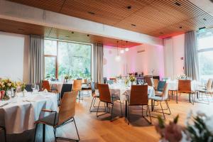 ein Esszimmer mit Tischen und Stühlen und rosa Wänden in der Unterkunft SeeLoge Eutin in Eutin