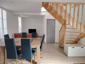 a dining room with a wooden table and blue chairs at Jauxvial 2 in Jaux