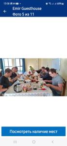 a group of people sitting at a table eating food at Мотель Эмир in Pokrovka