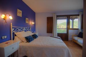 a blue bedroom with a bed and a window at La Posada De Santa Ana in Tramacastilla