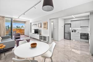 a kitchen and living room with a white table and chairs at Latitudes 1 Bedroom Apartment in Meneou