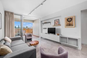 a living room with a couch and a tv at Latitudes 1 Bedroom Apartment in Meneou