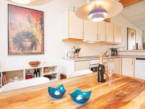 a kitchen with a wooden table with a bottle of wine at 6 person holiday home on a holiday park in Sæby in Sæby