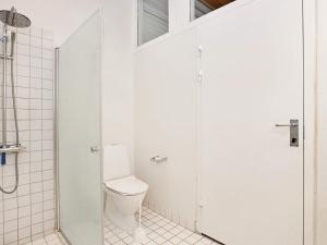 a white bathroom with a toilet and a shower at 6 person holiday home on a holiday park in Sæby in Sæby