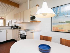 a kitchen with a white table with a blue bowl on it at 6 person holiday home on a holiday park in Sæby in Sæby +58 photos