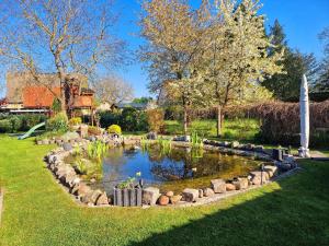 a garden with a pond in the grass at Ferienwohnung "Christina" in Steinkirchen