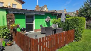 a fence in front of a green house at Ferienwohnung "Christina" in Steinkirchen