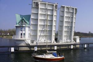 a sail boat in the water next to a building at Ferienwohnung Pauly in Niesgrau
