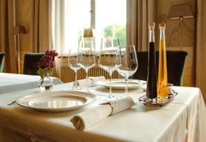 a table with wine glasses and wine bottles on it at Gutshaus Gevezin in Blankenhof