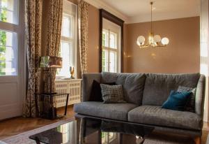 a living room with a gray couch and windows at Gutshaus Gevezin in Blankenhof