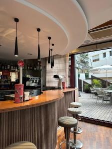a restaurant with a bar with stools and a patio at Hotel Acacias Suites & Spa in Lloret de Mar