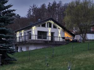 a large white house with a large deck on a hill at Haus Atlantis am Edersee in Bringhausen