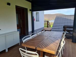 a wooden table and chairs on a balcony at Haus Atlantis am Edersee in Bringhausen