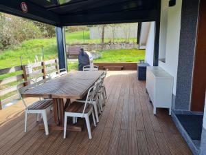 a wooden table and chairs sitting on a deck at Haus Atlantis am Edersee in Bringhausen +25 photos