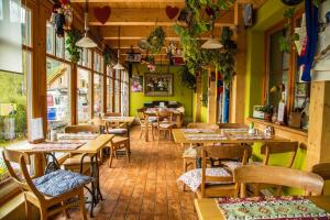 a restaurant with wooden tables and chairs and windows at Hotel Modřin wellness v ceně in Pec pod Sněžkou