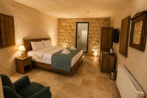 a bedroom with a bed and a chair in it at Kayaharman cave otel in Nar